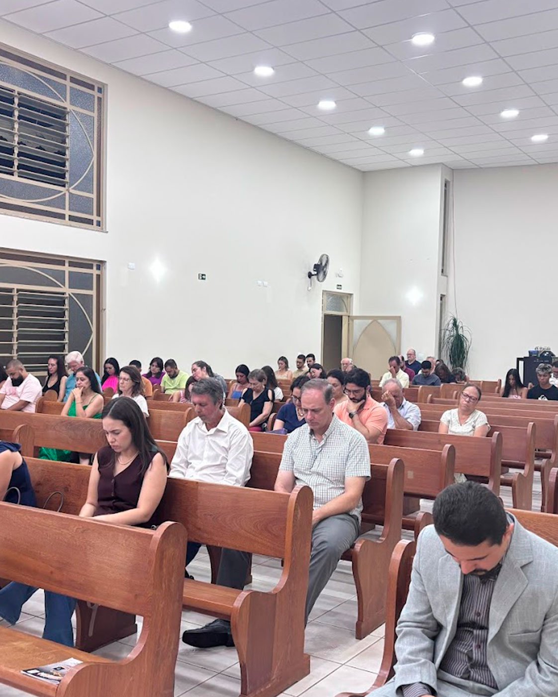 Pessoas reunidas em oração durante o culto na Igreja Presbiteriana da Vila Brasil.